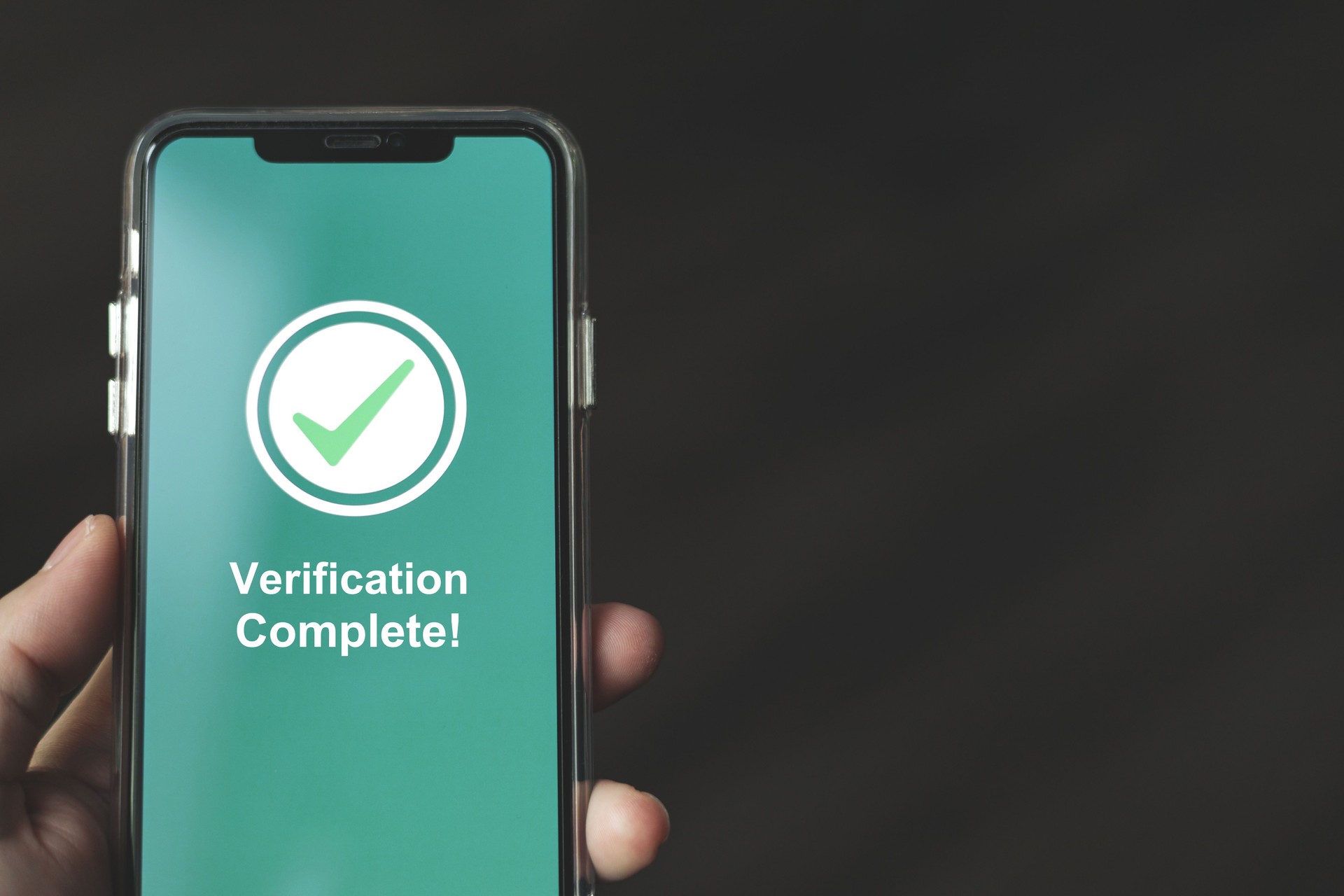 Businessman shows notification Verification Complete on smartphone. concept of technology authentication for entering security systems